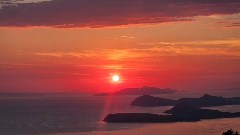 A photo of the sea and the sun setting, orange and warm colours