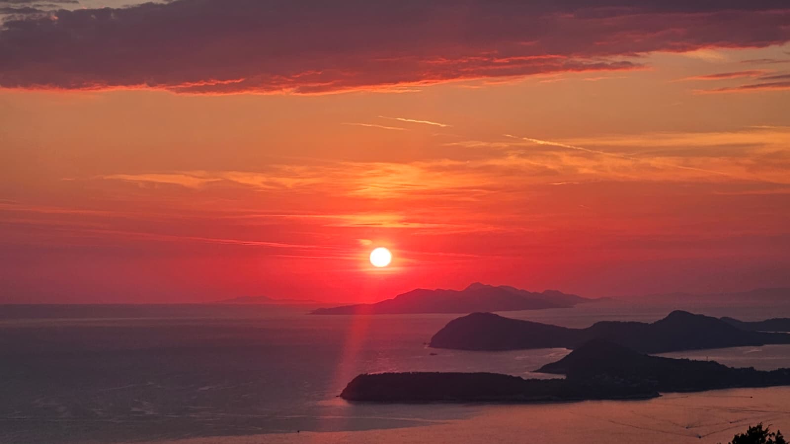 A photo of the sea and the sun setting, orange and warm colours